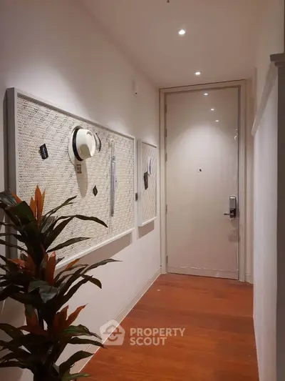 Stylish apartment entrance with wooden flooring and decorative wall art
