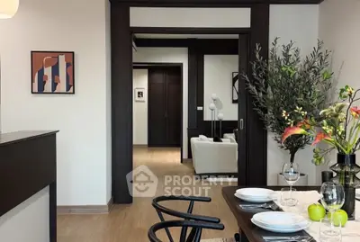 Elegant dining area with modern decor and view into cozy living room