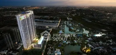 Stunning aerial view of a modern high-rise building with illuminated cityscape at dusk.