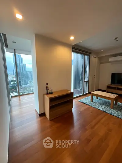Spacious modern living room with wooden flooring and city view
