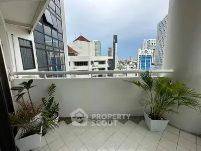 Charming city balcony with potted plants and skyline view, perfect for urban relaxation.