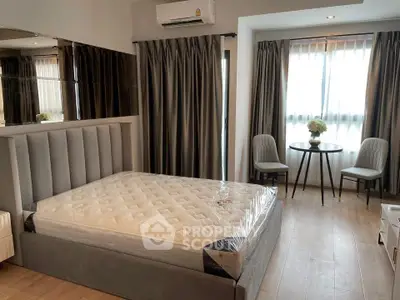 Modern bedroom with stylish decor and natural light, featuring a comfortable bed and elegant furnishings.