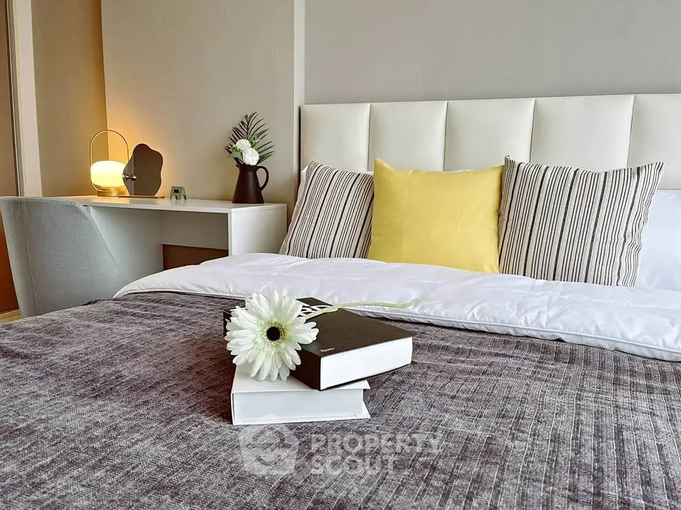 Elegant bedroom with modern decor, featuring a cozy bed, stylish pillows, and a chic desk lamp.