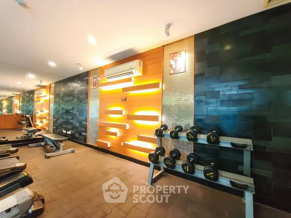 Modern gym with stylish lighting and fitness equipment in upscale residential building.