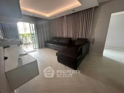 Modern living room with sleek design and large windows opening to a balcony, featuring a stylish L-shaped sofa.