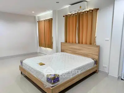 Spacious bedroom with modern wooden bed and air conditioning