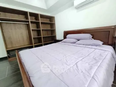 Spacious bedroom with wooden bed and built-in wardrobe, perfect for comfort and storage.