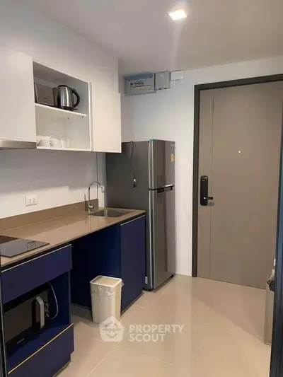 Modern kitchen with sleek appliances and stylish cabinetry in a contemporary apartment.
