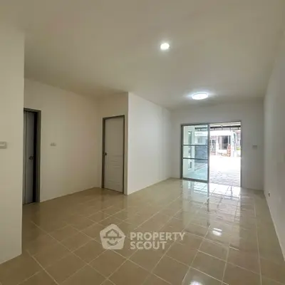 Spacious open-plan living area with tiled flooring and ample natural light.