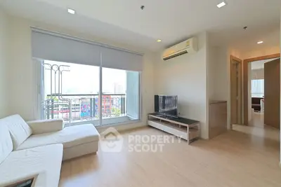 Spacious living room with modern decor and city view balcony in a high-rise apartment.