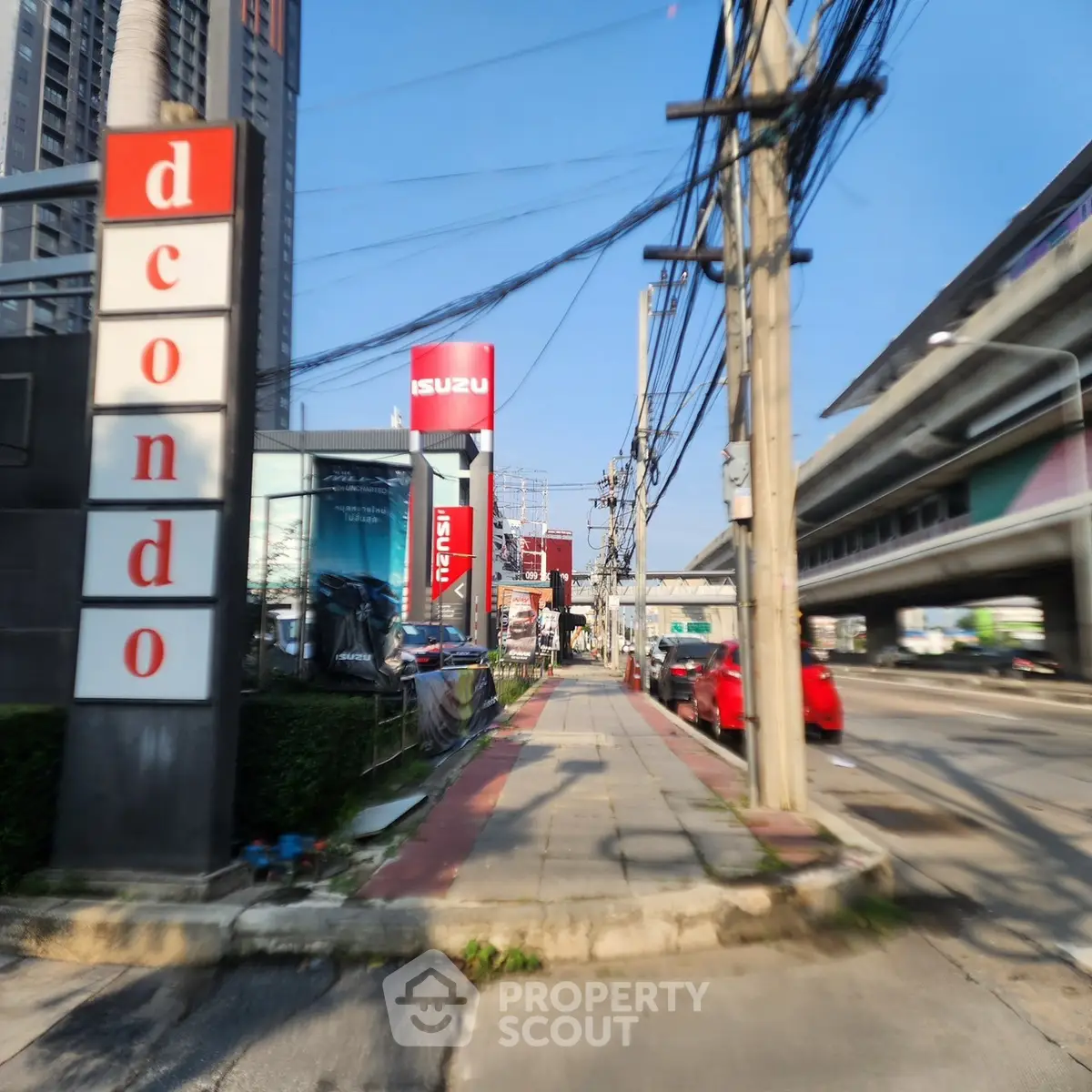 Street view of modern condominium building with nearby amenities and urban infrastructure.