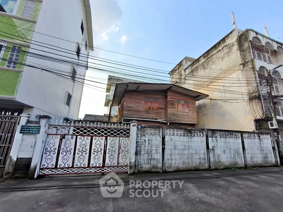 Charming rustic wooden house nestled between urban buildings, showcasing unique architectural contrast.