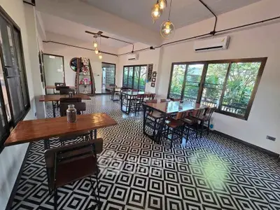Chic dining area with geometric floor tiles and large windows offering lush garden views.