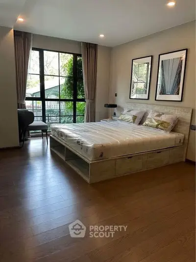 Spacious bedroom with large window and elegant decor