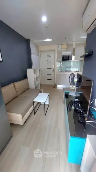 Modern living room with sleek furniture and open kitchen layout in a stylish apartment.