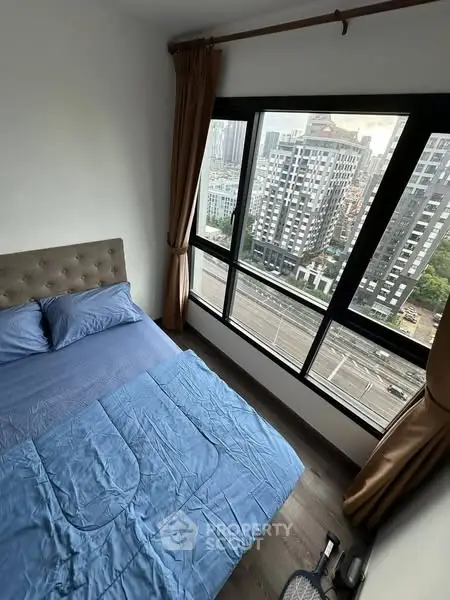 Cozy bedroom with stunning city view from large windows in modern apartment
