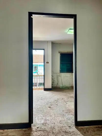 Spacious interior with potential for renovation, featuring large windows and natural light.