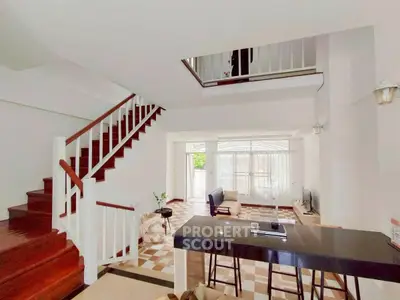 Spacious modern living room with open layout and elegant staircase, perfect for family gatherings.