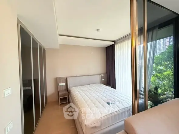 Spacious bedroom with large windows and garden view in modern apartment