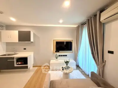 Modern living room with sleek kitchen, stylish decor, and natural light.