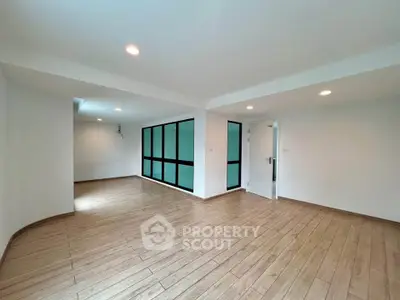 Spacious modern living room with wooden flooring and large windows
