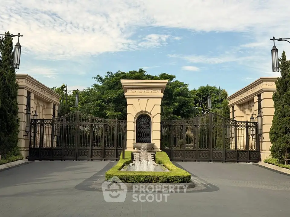 Luxurious gated entrance with elegant fountain and lush greenery