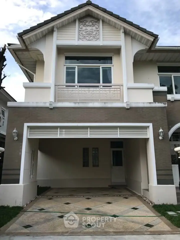 Elegant two-story house with spacious driveway and modern architectural design.