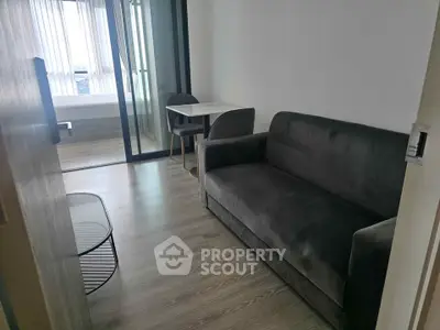 Modern living room with sleek sofa and dining area in a compact apartment