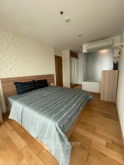 Spacious bedroom with modern decor and hardwood flooring