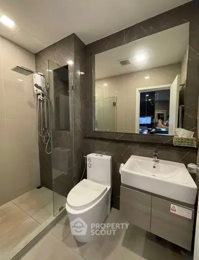 Modern bathroom with sleek design, glass shower, and contemporary fixtures in a stylish apartment.