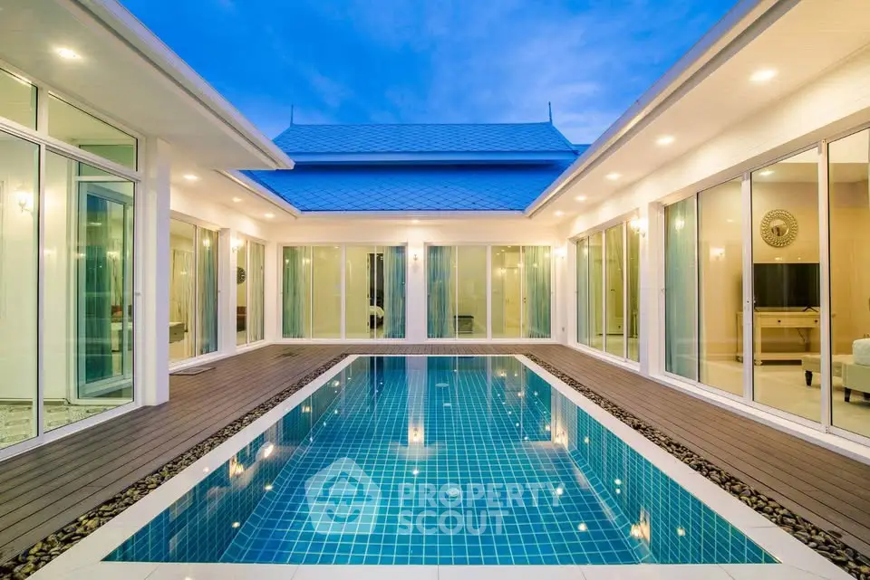 Luxurious modern villa with stunning pool and elegant architecture under a vibrant blue sky.
