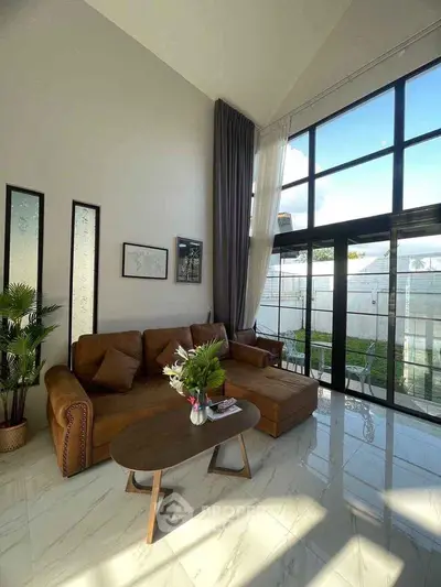 Luxurious living room with high ceilings and large windows offering abundant natural light.