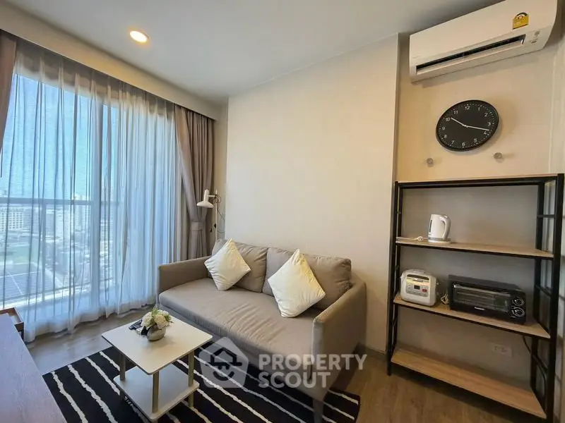 Modern living room with cozy sofa, air conditioning, and city view through large window.