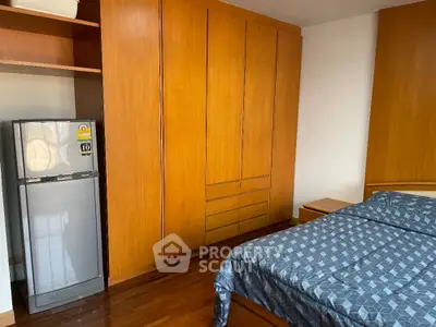 Spacious bedroom with wooden wardrobe and modern refrigerator