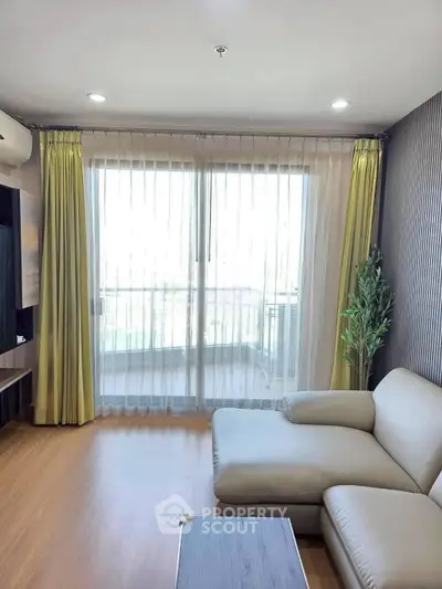 Modern living room with large windows and stylish decor in a high-rise apartment.