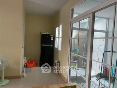 Spacious kitchen area with modern black fridge and sliding glass doors leading to patio.