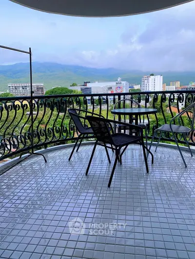 Spacious balcony with stunning city and mountain views, perfect for relaxation and outdoor dining.