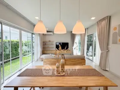 Spacious modern living room with large windows and garden view, perfect for family gatherings.