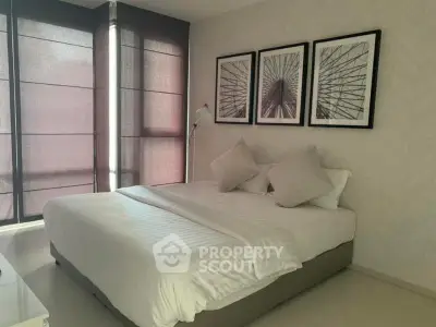 Elegant bedroom with modern decor and large windows in a stylish apartment.