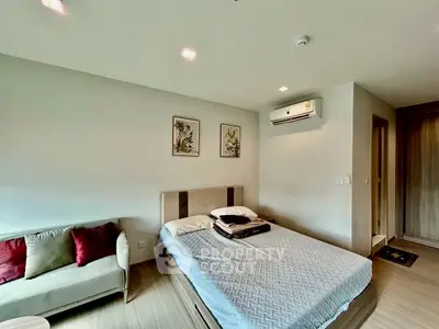 Modern bedroom with cozy bed, stylish decor, and air conditioning unit.