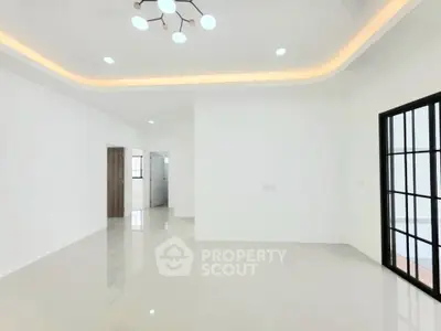 Spacious modern living room with elegant lighting and sleek tile flooring.