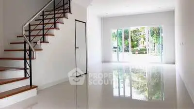 Spacious modern interior with glossy floors and staircase, ample natural light.