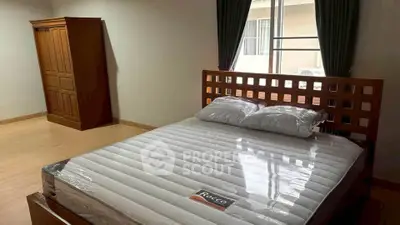 Spacious bedroom with wooden furniture and natural light