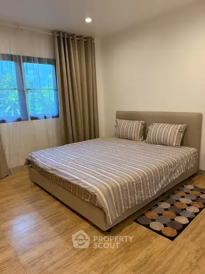 Cozy bedroom with stylish decor and large window for natural light