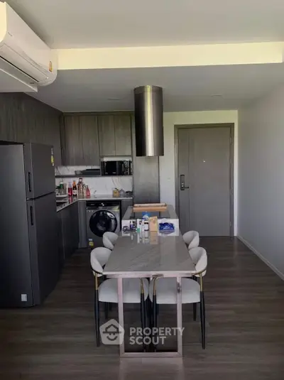 Modern kitchen with dining area, featuring sleek appliances and stylish decor.