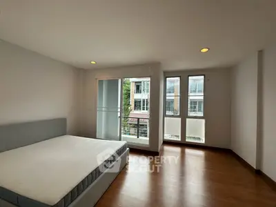 Spacious bedroom with large windows and balcony access in modern apartment