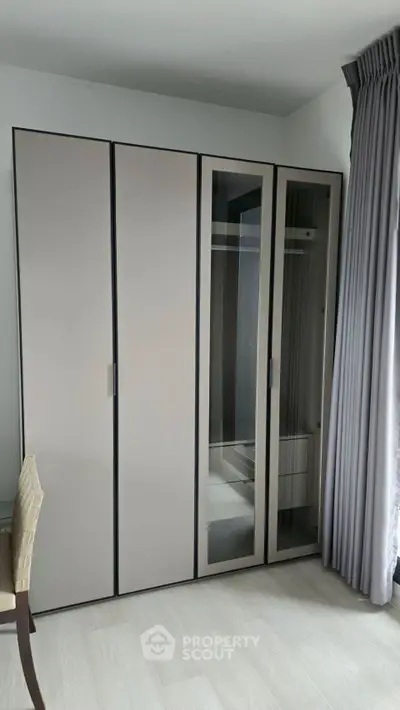 Modern bedroom with sleek wardrobe and elegant curtains