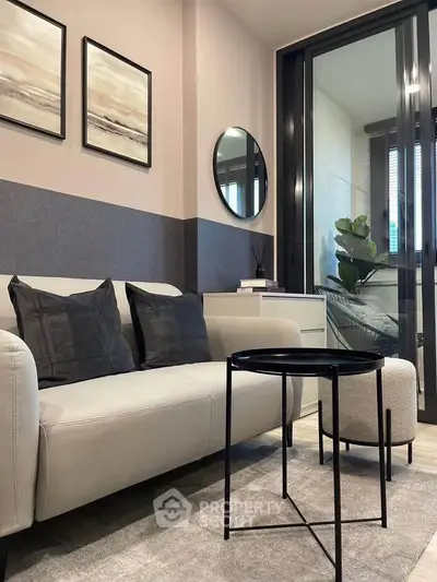 Modern living room with stylish decor and glass partition in a cozy apartment.