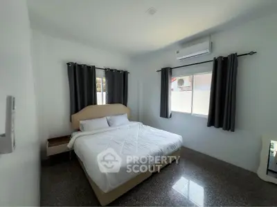 Modern bedroom with large bed and air conditioning, featuring sleek design and natural light.