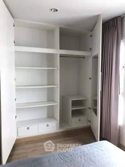 Spacious bedroom with built-in white wardrobe and natural light